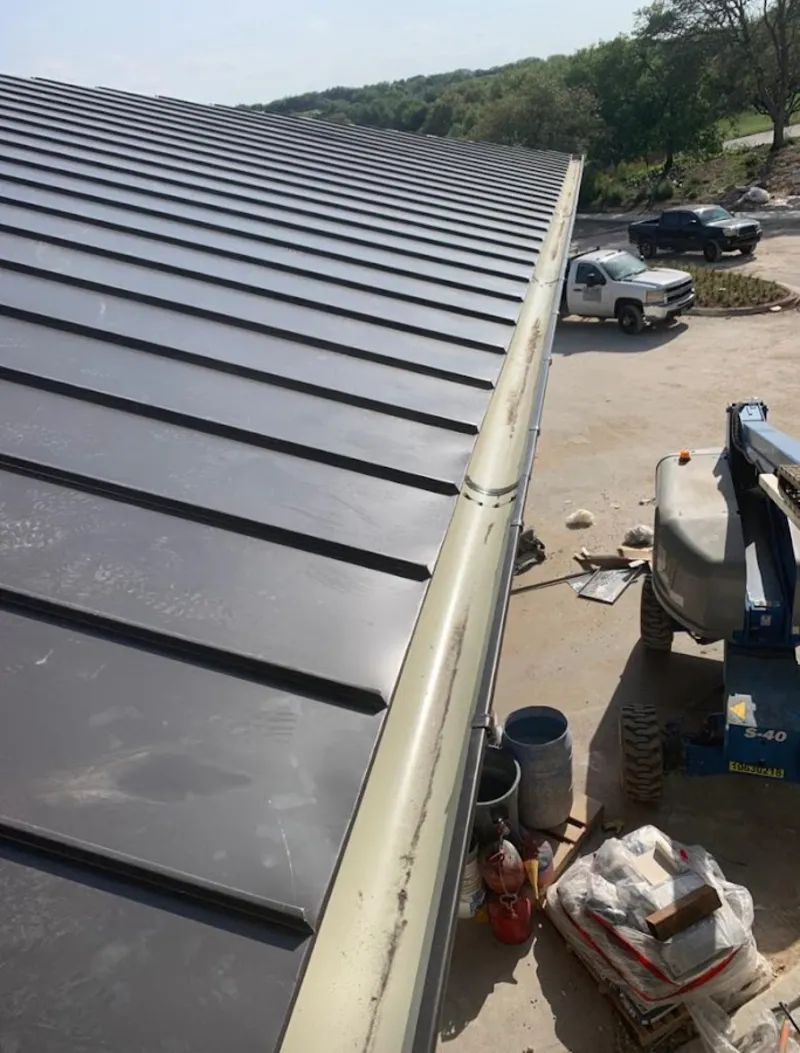 Standing seam panel and gutter detail on a metal roofing jobsite in Shafter